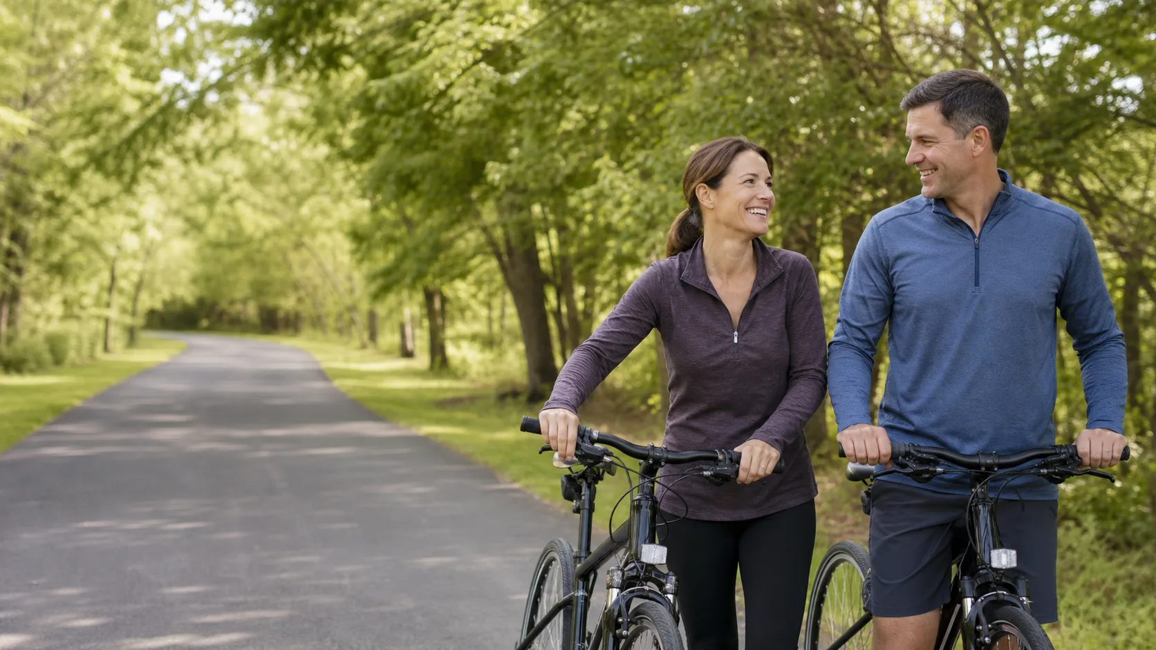 Active midlife couple cycling together outdoors